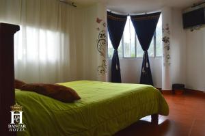 um quarto com uma cama verde com cortinas e uma janela em Hotel Dancar em Pamplona