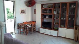 a living room with a dining room table and a television at SicilyHome in Marzamemi