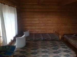 ein Schlafzimmer mit einem Bett in einem Blockhaus in der Unterkunft Kempings Ozianna in Naujene