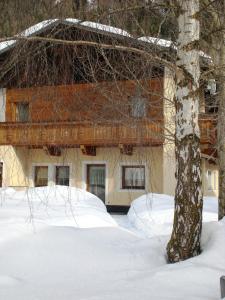 budynek z drzewem w śniegu w obiekcie Haus am Brunnen w mieście Umhausen