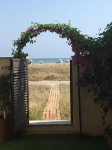 an open door with a view of a brick path at Beach flat with garden in Castelldefels