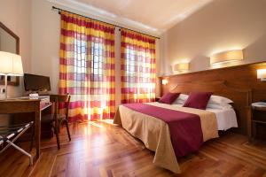 - une chambre avec un lit et un bureau avec un ordinateur dans l'établissement TH Borca di Cadore - Park Hotel Des Dolomites, à Borca di Cadore