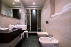 a bathroom with two sinks and a toilet and a shower at TH Borca di Cadore - Park Hotel Des Dolomites in Borca di Cadore
