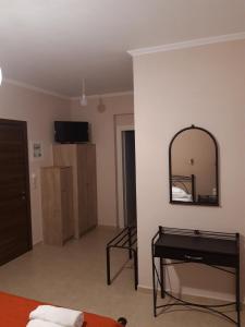 a living room with a mirror and a table at Valedina Rooms in Nikiana