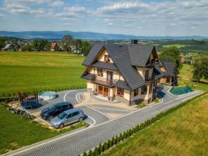 an aerial view of a house with cars parked in the driveway at u kowola in Szaflary