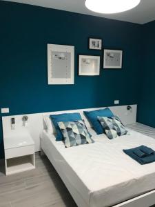 una camera con un letto con una parete blu di B&B Luxury Apartments a Pulsano