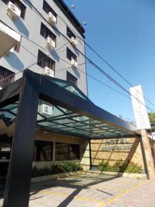 a building with a glass canopy in front of a building at Hotel Comendador in Três Rios