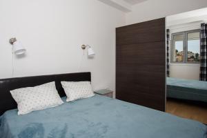 ein Schlafzimmer mit einem Bett mit zwei Kissen und einem Spiegel in der Unterkunft Koi Town Heart in Budva