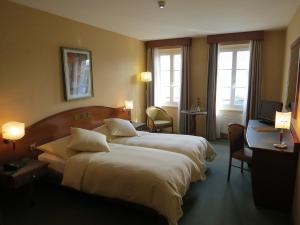 Cette chambre comprend deux lits et une télévision. dans l'établissement Hôtel du Port, à Lausanne