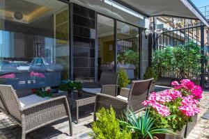 une terrasse avec des chaises et des fleurs devant un bâtiment dans l'établissement Hotel Shepherds Bush London, à Londres