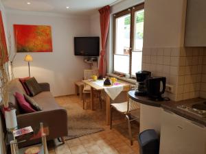 cocina y sala de estar con sofá y mesa en Ferienhaus Lyhs, en Fehrenbach