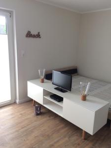 ein Wohnzimmer mit einem weißen Tisch und einem Computer darauf in der Unterkunft „Lüttje Nüst“ in Emden