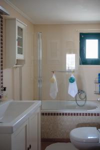 a bathroom with a shower and a tub and a sink at Artemis Sunrise in Artemida