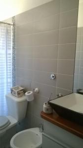 y baño con aseo blanco y lavamanos. en Descanso en Piriápolis, en Piriápolis