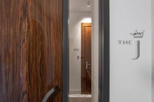 Habitación con puerta de cristal y pared de madera. en The Joseph, en Vilna