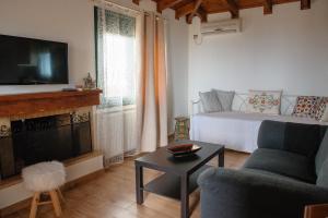 a living room with a bed and a couch and a tv at Artemis Sunrise in Artemida