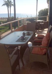 una mesa y sillas en un balcón con vistas al océano en Pez Espada 1ª Línea Playa y Parking Incluido, en Torremolinos