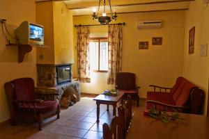 a living room with a fireplace and a tv at Casas rurales amable- yeste in Cortijo Prados