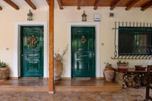 two green doors on the side of a building at Artemis Sunrise in Artemida