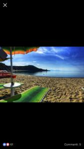 een strand met een parasol en een tafel en stoelen bij B&b Slow life in Marina di Camerota