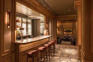 un bar en un restaurante con taburetes en una habitación en Lowell Hotel en Nueva York