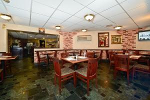 a dining room with wooden tables and chairs at Howard Johnson by Wyndham Newark Airport in Newark
