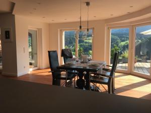 a dining room with a table and chairs with a view at Schwarzwald Lodge Oppenau in Oppenau