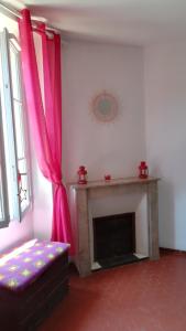 a living room with a fireplace with a pink curtain at LOLIFAN en PROVENCE in Brignoles