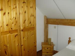 WibrinにあるLa Maison en Boisの木製の壁のベッドルーム1室、ベッド1台、ドレッサーが備わります。