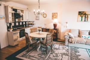 a kitchen and living room with a table and a couch at Apartamentai Juodkranteje in Juodkrantė +11 photos