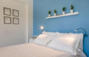 a bedroom with blue walls and a bed with white pillows at Eshkol Housing Haifa - Moriya Suites Boutique Complex in Haifa