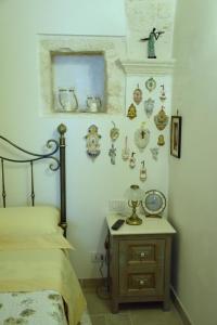 a bedroom with a bed and a table with a clock on the wall at Edoné in Locorotondo