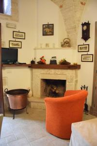 a living room with a fireplace and orange chairs at Edoné in Locorotondo