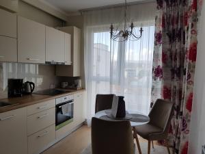 クルジュ・ナポカにあるTraian Residenceのキッチン(テーブル、椅子付)、窓