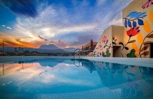 een zwembad van het resort met een zonsondergang op de achtergrond bij Hotel Carlos I in Benidorm