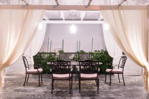 a table and chairs in a room with curtains at Studios Filipidis in Chrysi Ammoudia