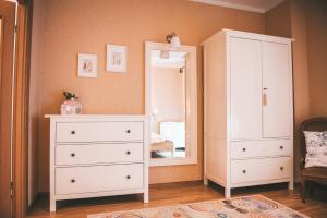 a bedroom with a white dresser and a mirror at Apartamentai Juodkranteje in Juodkrantė