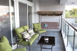 a balcony with chairs and a bed and a table at Blue4Aqua Apartments in Kavála