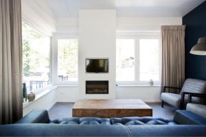 a living room with a couch and a fireplace at Bok's Bungalowpark in Garderen