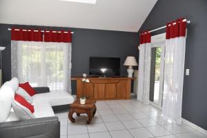 a living room with a white couch and red curtains at Le cerisier in Kaysersberg