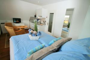 a bedroom with a blue bed with a basket on it at Ferienwohnungen Wyk/Föhr in Wyk auf Föhr