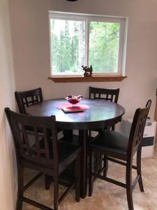 a dining room table with four chairs and a window at Peaceful Talkeetna Getaway #1 in Talkeetna