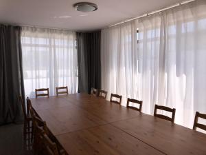 ブワディスワボボにあるWilla Dwie Mewyのカーテン付きの客室内に大きな木製テーブルと椅子があります。