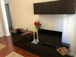 un soggiorno con un centro di intrattenimento nero e una TV a schermo piatto di Arroios BnB a Lisbona