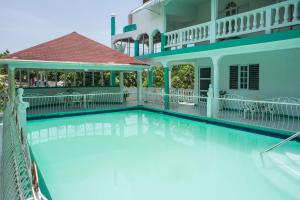 a swimming pool in front of a house at Diamond Villa Guest House in Montego Bay