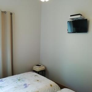 1 dormitorio con 1 cama y TV en la pared en Sweet Home for Holidays, en Machico