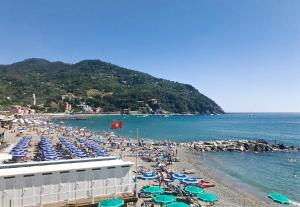 a beach with a bunch of chairs and umbrellas at La Casa di Letizia in Levanto