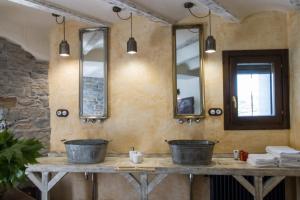 a bathroom with two sinks and two mirrors at Hotel Posada Al Vent - Adults Only in Coscojuela de Sobrarbe