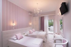 a hotel room with two beds and a tv at Studios Filipidis in Chrysi Ammoudia
