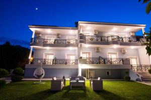 a white house with a lawn in front of it at Studios Filipidis in Chrysi Ammoudia +42 photos